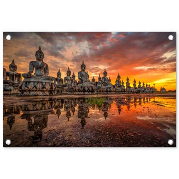 Rij van Boeddha-beelden bij zonsondergang
